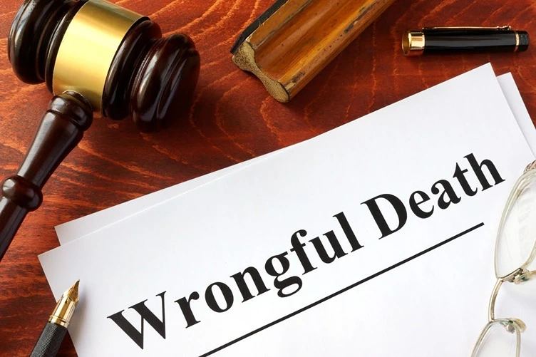 Wrongful death vs survival action paper surrounded by a gavel and pen.