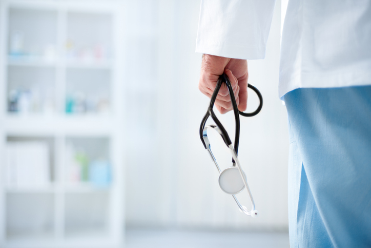 closeup of doctor's hand holding stethoscope - How to choose a medical malpractice lawyer