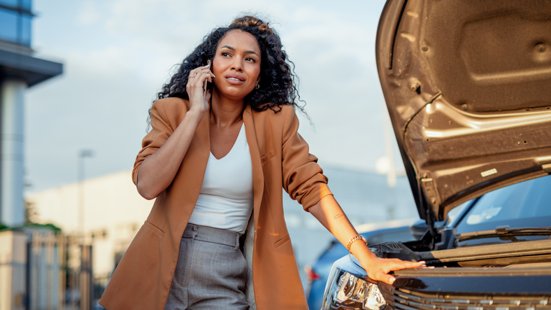 Woman on her phone leaning on her car - what to do if a driver leaves the scene after a car accident in Florida?